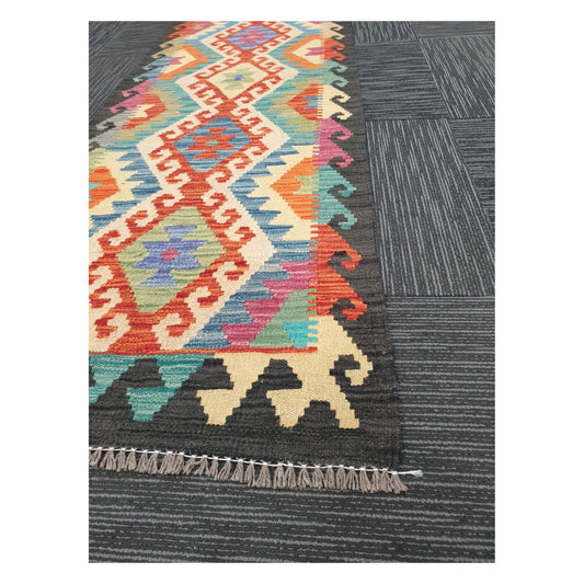 Close view of Afghan Chobi Kilim runner showing linked diamond pattern and end fringe, 194 x 63 cm