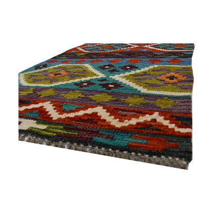 Angled fringe and flatweave detail of Afghan Chobi Kilim wool rug showing teal, rust, olive and burgundy geometric pattern