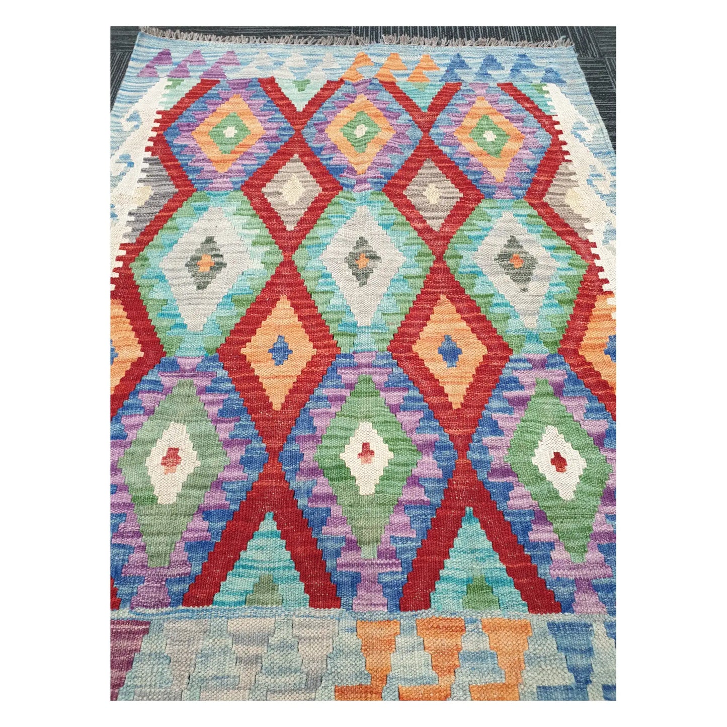 Close-up of Chobi Kilim rug with diamond trellis motifs in coral red, mint green, lilac, and powder blue, 115 x 86 cm