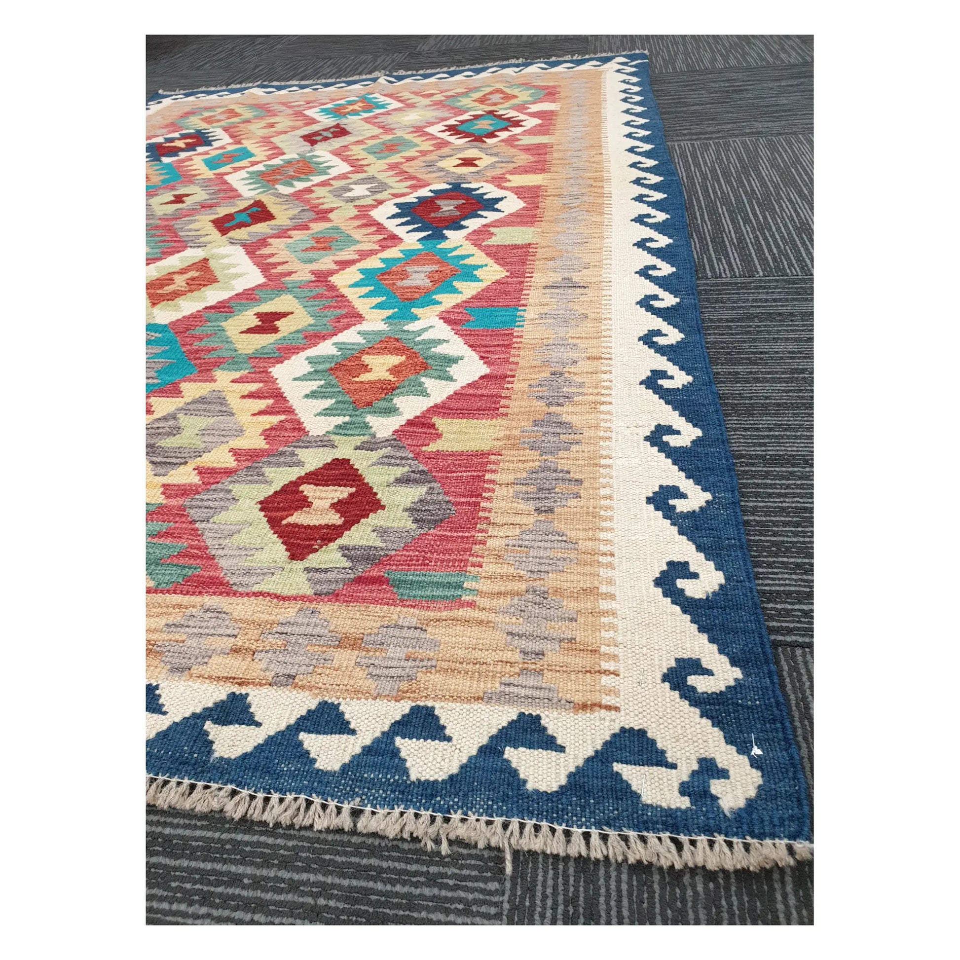 Angled detail of Afghan Chobi Kilim showing fringe, blue border, and handwoven geometric pattern, 178 x 128 cm