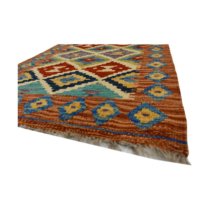 Angled fringe and flatweave detail of Afghan Chobi Kilim wool rug showing rust, blue and ivory geometric pattern