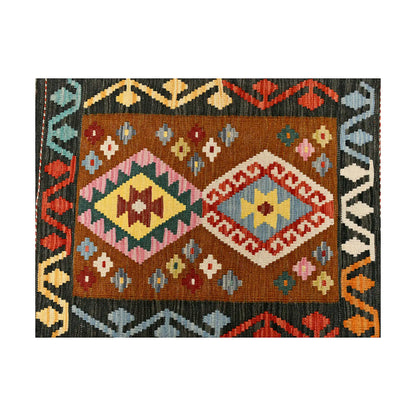 Close-up of Afghan Chobi Kilim wool rug showing charcoal border, twin diamond medallions and multicolour tribal motifs