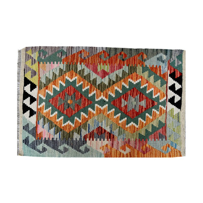 Close-up of Afghan Chobi Kilim wool rug showing orange twin diamond motifs, sage ground and colourful zigzag border