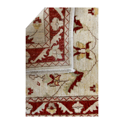 Folded-corner detail of Afghan Chobi runner showing the reverse weave beside its beige floral front and red border