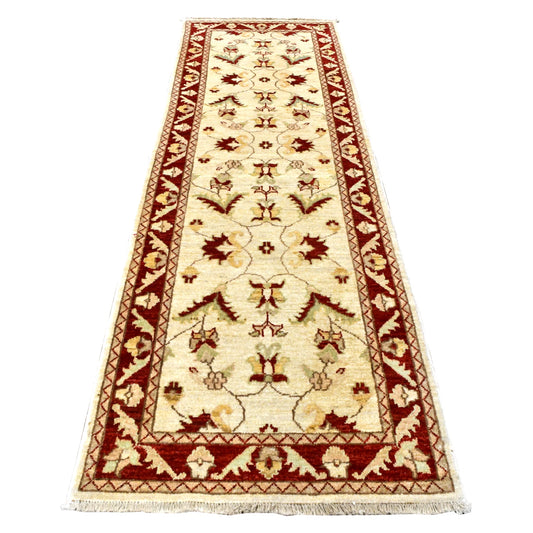 Full view of Afghan Chobi runner with warm beige floral field, deep red patterned border and fringe, 282 x 89 cm