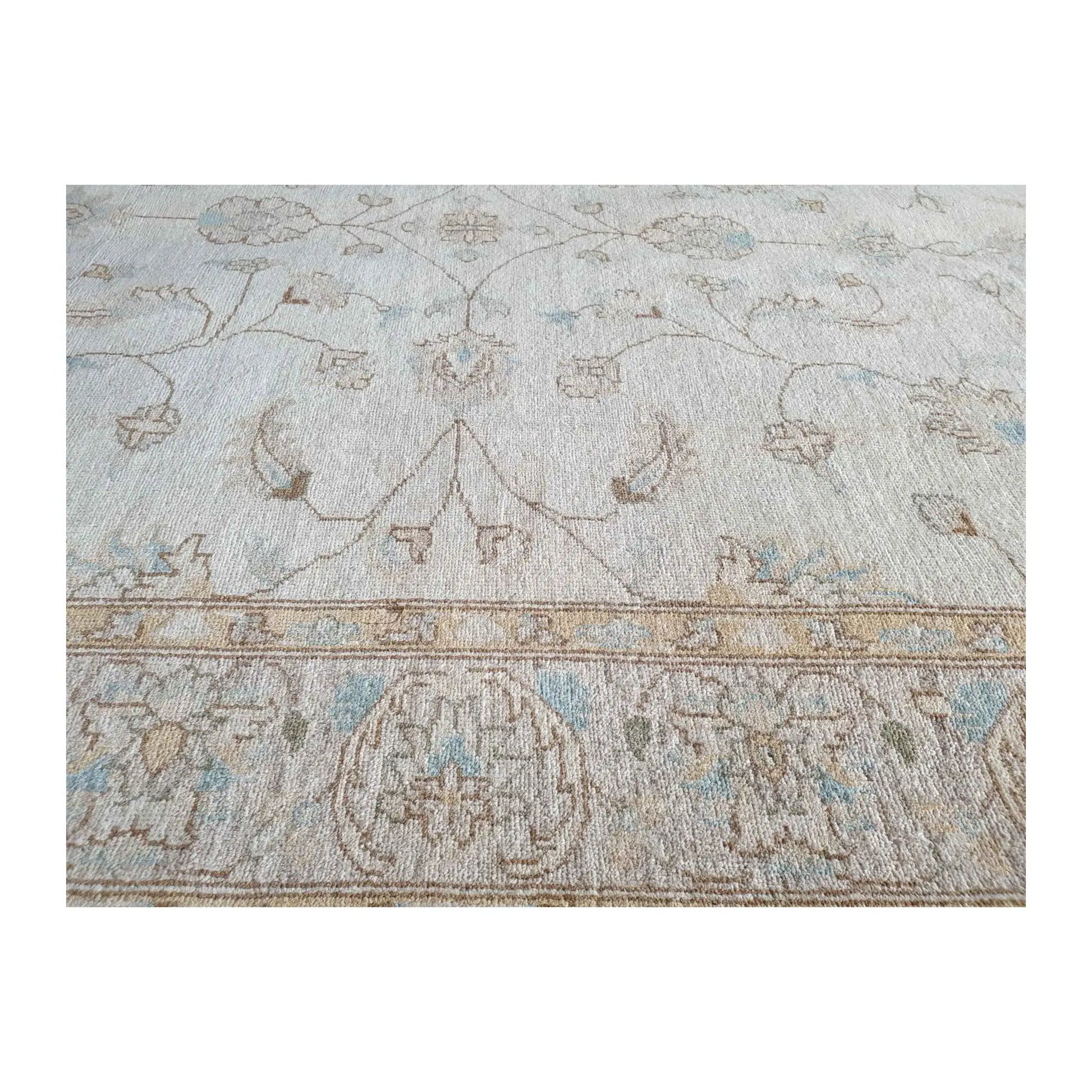 Border detail of Afghan Chobi soft beige rug showing pale blue and beige tones