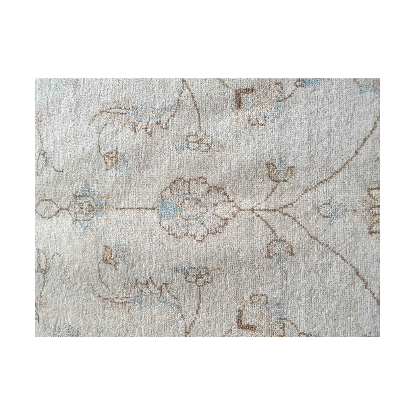 Floral detail of Afghan Chobi rug showing soft beige wool pile and fine pattern