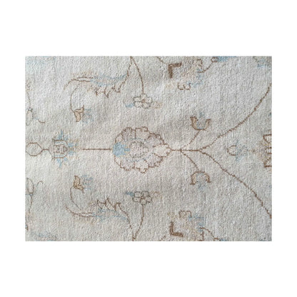 Floral detail of Afghan Chobi rug showing soft beige wool pile and fine pattern