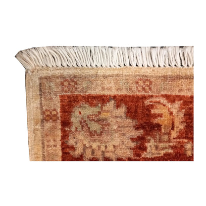 Corner detail showing cream fringe, rust-red floral border and wool pile