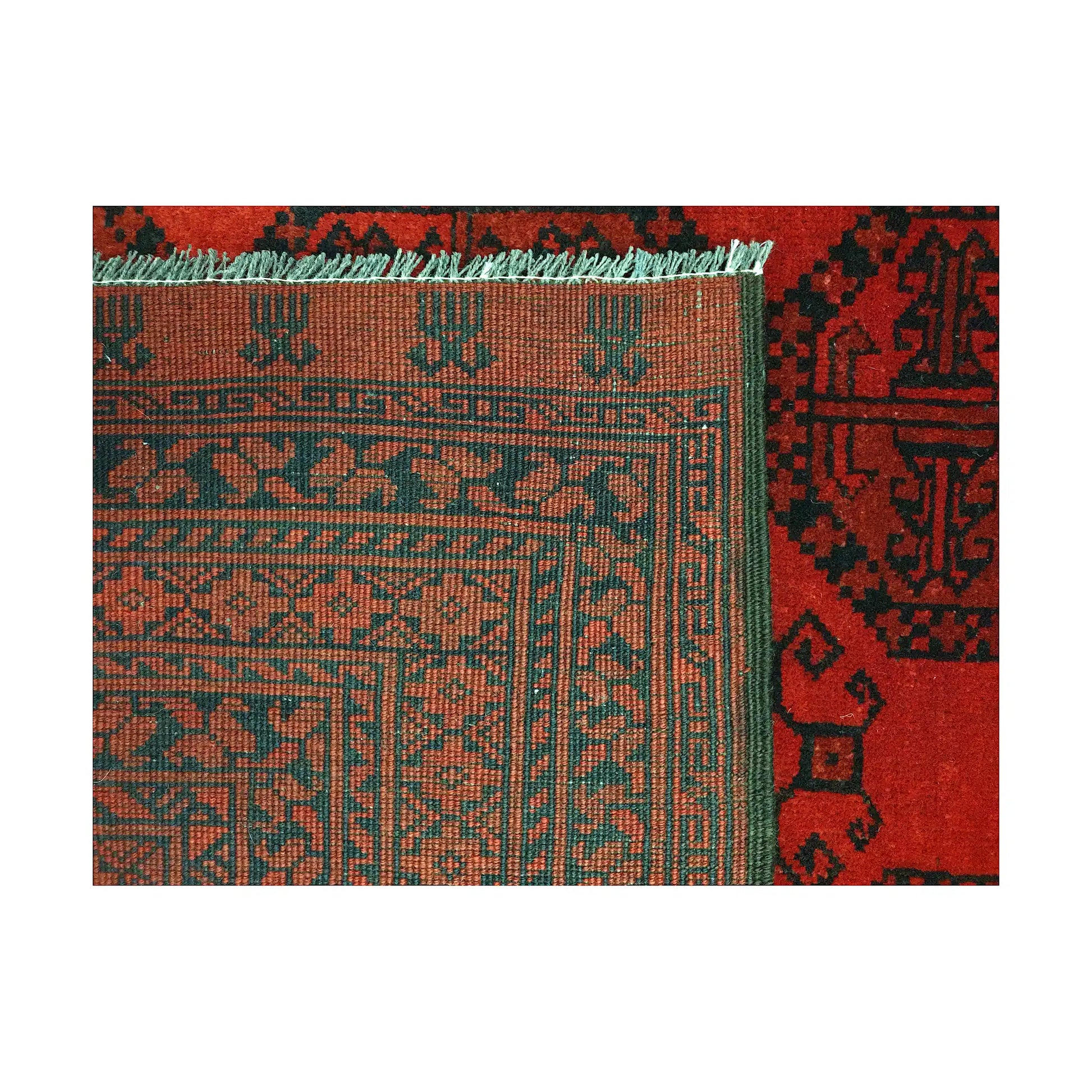 Folded corner detail of Afghan Ersari rug showing the back of the rug, fringe and tonal red front pattern