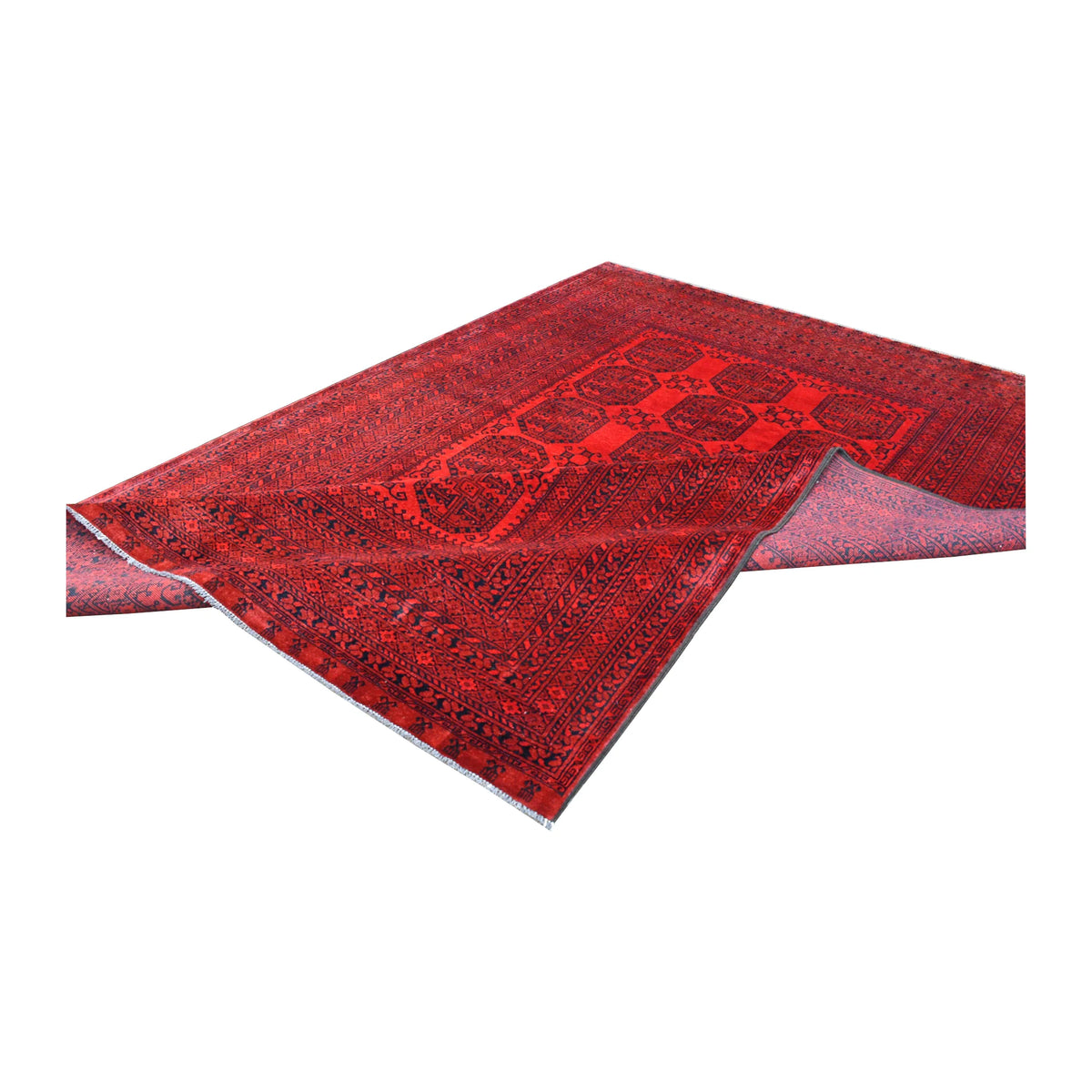 Folded view of Afghan Ersari rug showing its patterned red pile, reverse weave and pale fringe