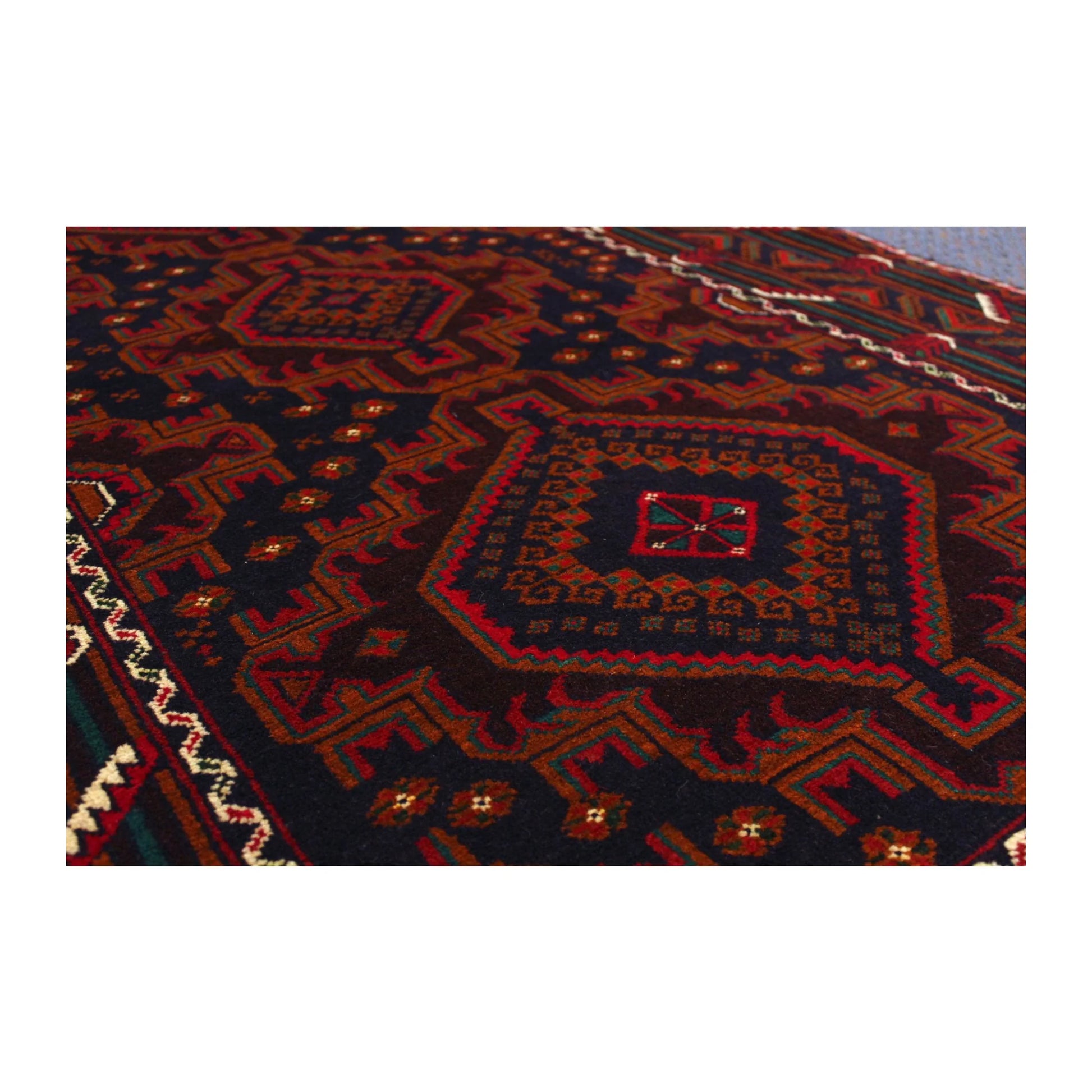 Close-up of Afghan Fine Baluchi rug showing a stepped diamond medallion and wool pile texture