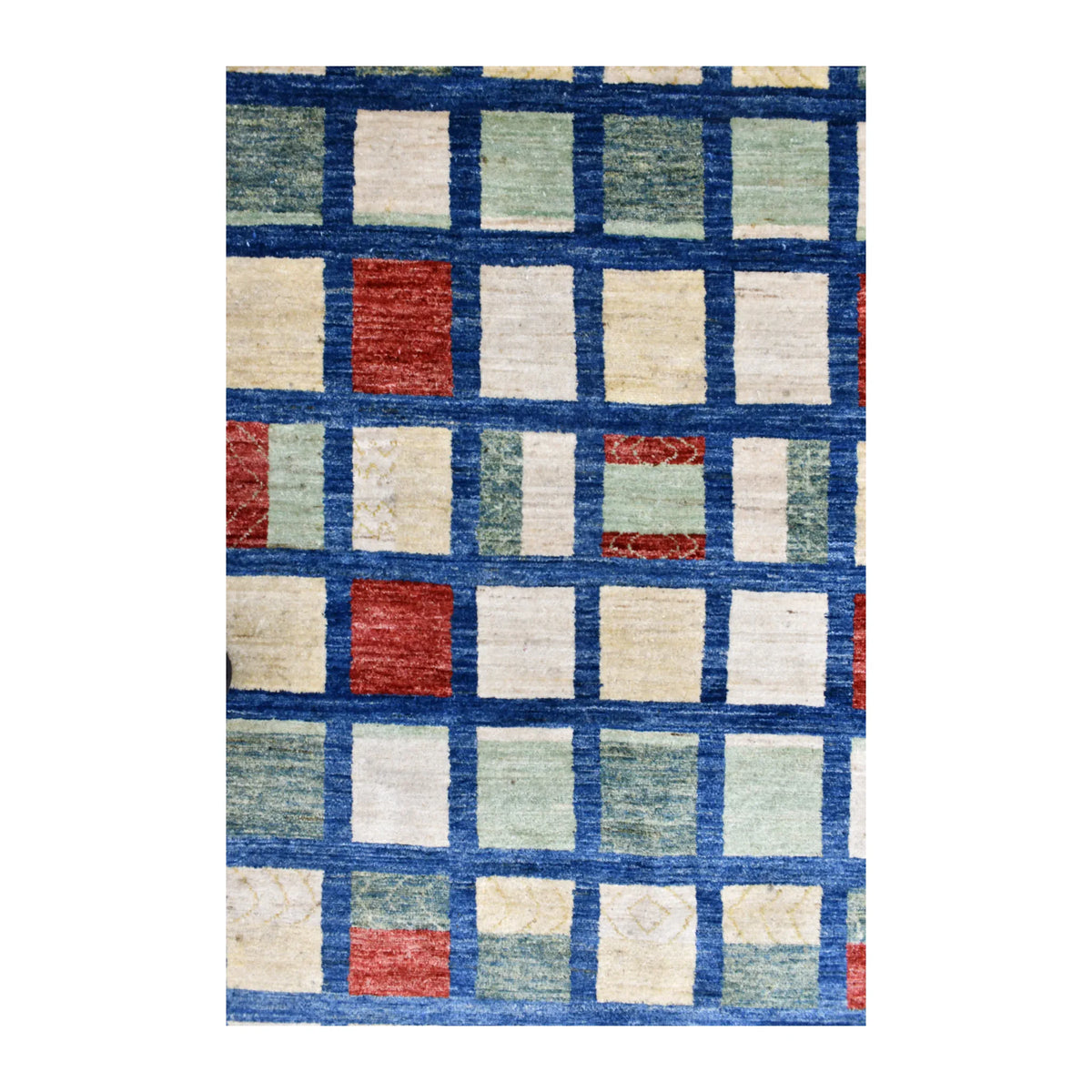 Close-up of ivory, rust and sage rectangles separated by dark-blue lines in the Gabbeh rug’s central grid