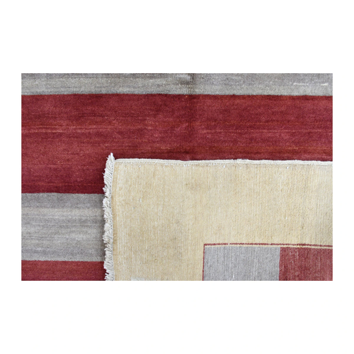 Folded-corner detail of Afghan Gabbeh rug showing the striped front, reverse weave and finished edge