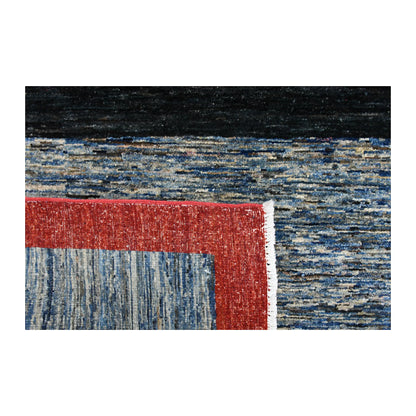 Folded-corner detail of Afghan Gabbeh rug showing the reverse weave, red border, blue field and pale fringe