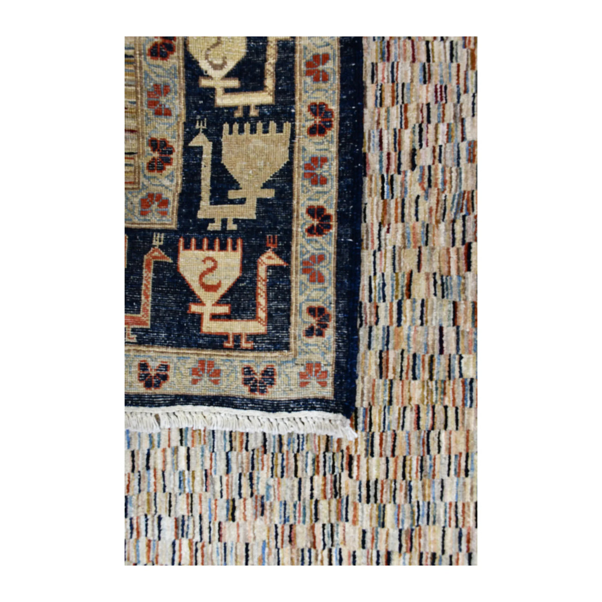 Folded-corner detail of Afghan Gabbeh rug showing the reverse weave, multicolour pile and navy patterned border