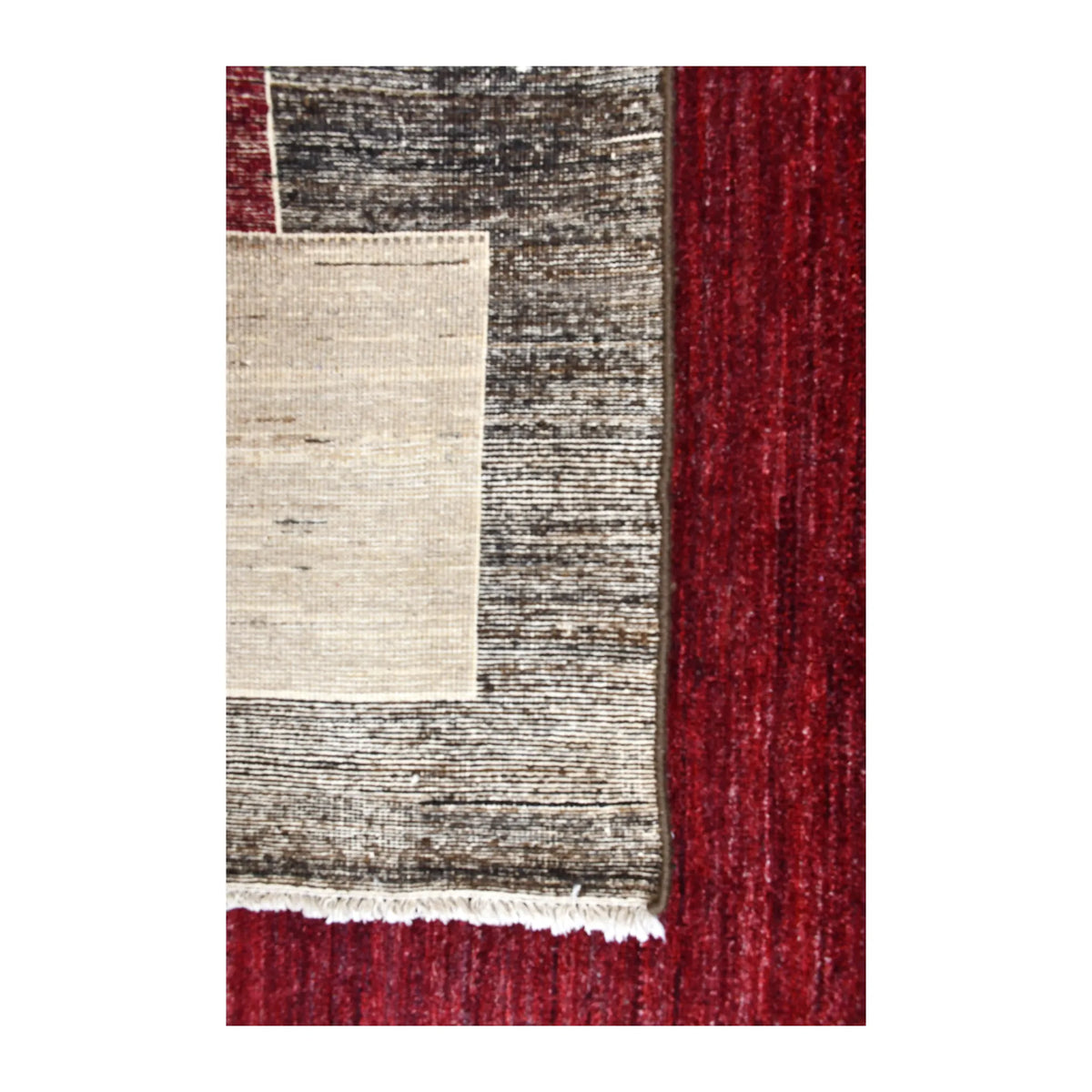 Folded-corner detail of Afghan Gabbeh rug showing the reverse weave, tonal front pile and off-white corner block
