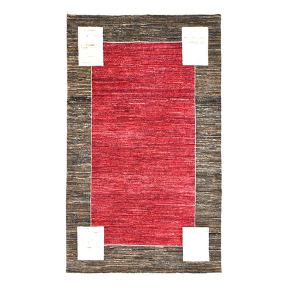 Full view of Afghan Gabbeh hand-knotted wool rug with tonal red field, charcoal-brown frame and off-white corner blocks, 243 x 162 cm
