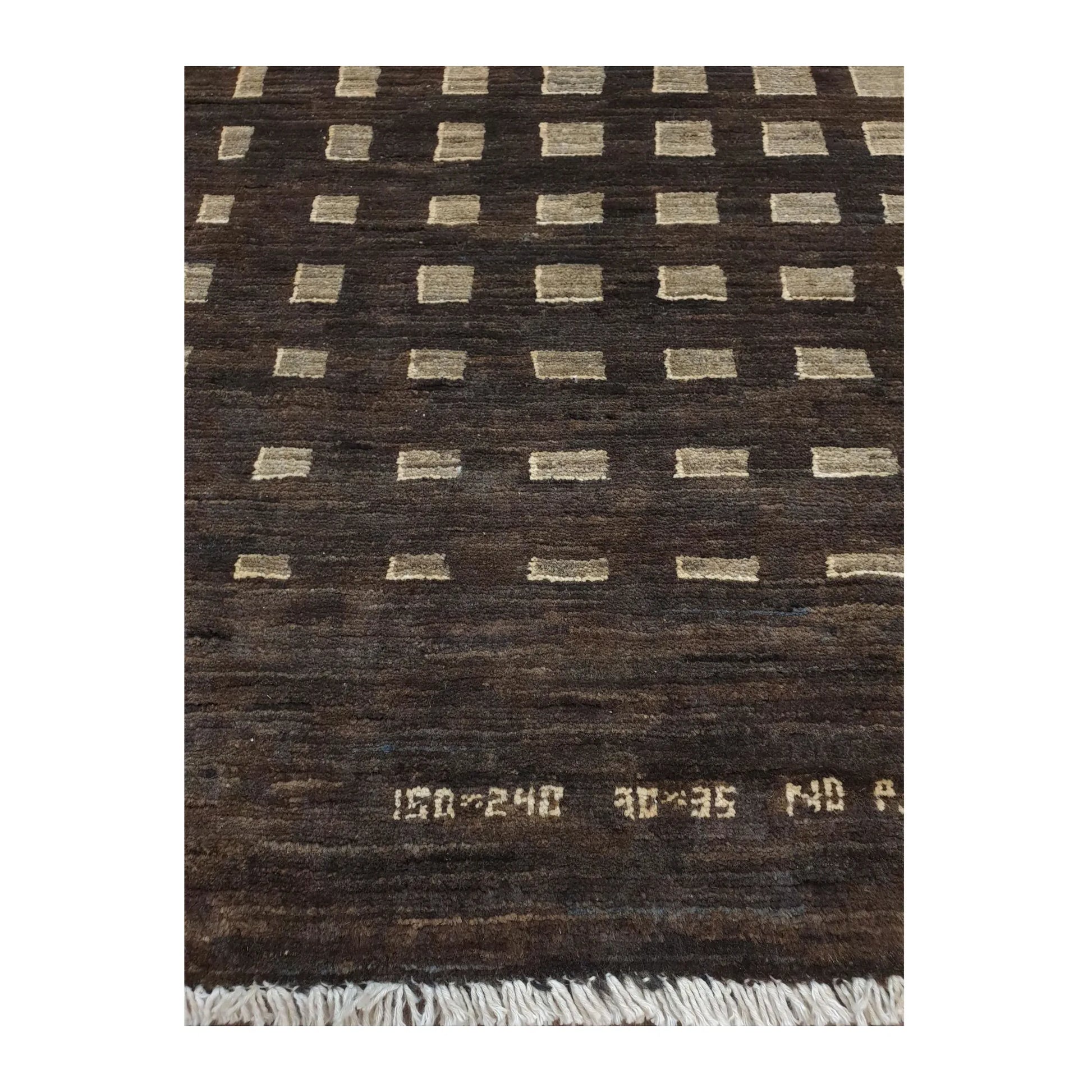 Close-up of Afghan Gabbeh natural wool rug showing the geometric lattice pattern, tonal wool texture and fringe