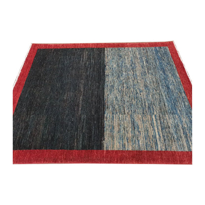 Angled view of Afghan Gabbeh wool rug with dark navy and blue field, 196 x 157 cm