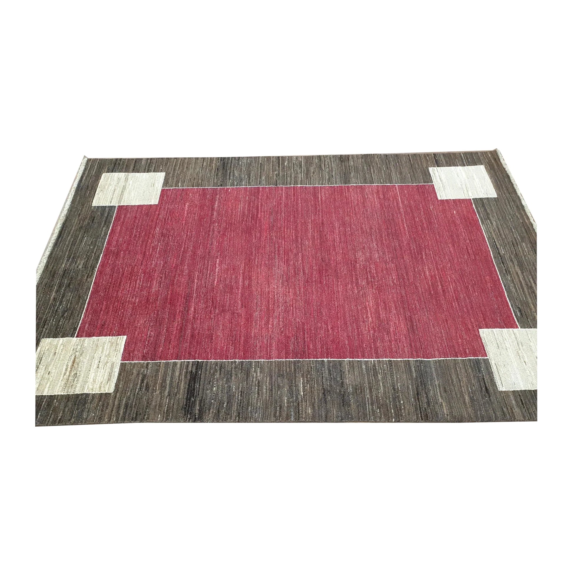 Angled full view of Afghan Gabbeh hand-knotted wool rug showing red field and minimalist colour-block border, 243 x 162 cm