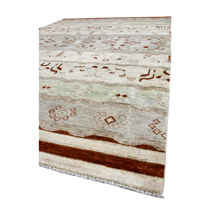Angled end view of Afghan Gabbeh wool rug showing rust-red border bands, pale mint field and fringe