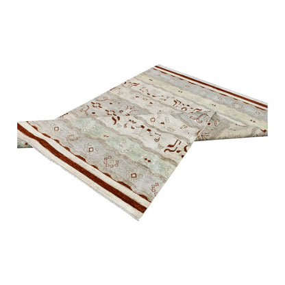 Folded view of Afghan Gabbeh wool rug showing pale mint and off-white bands, rust-red motifs and patterned pile