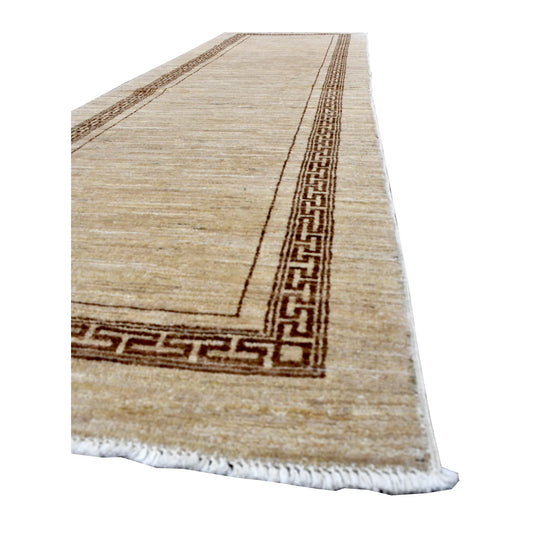 Angled view of Afghan Gabbeh runner showing its warm beige field, dark brown geometric border and white fringe