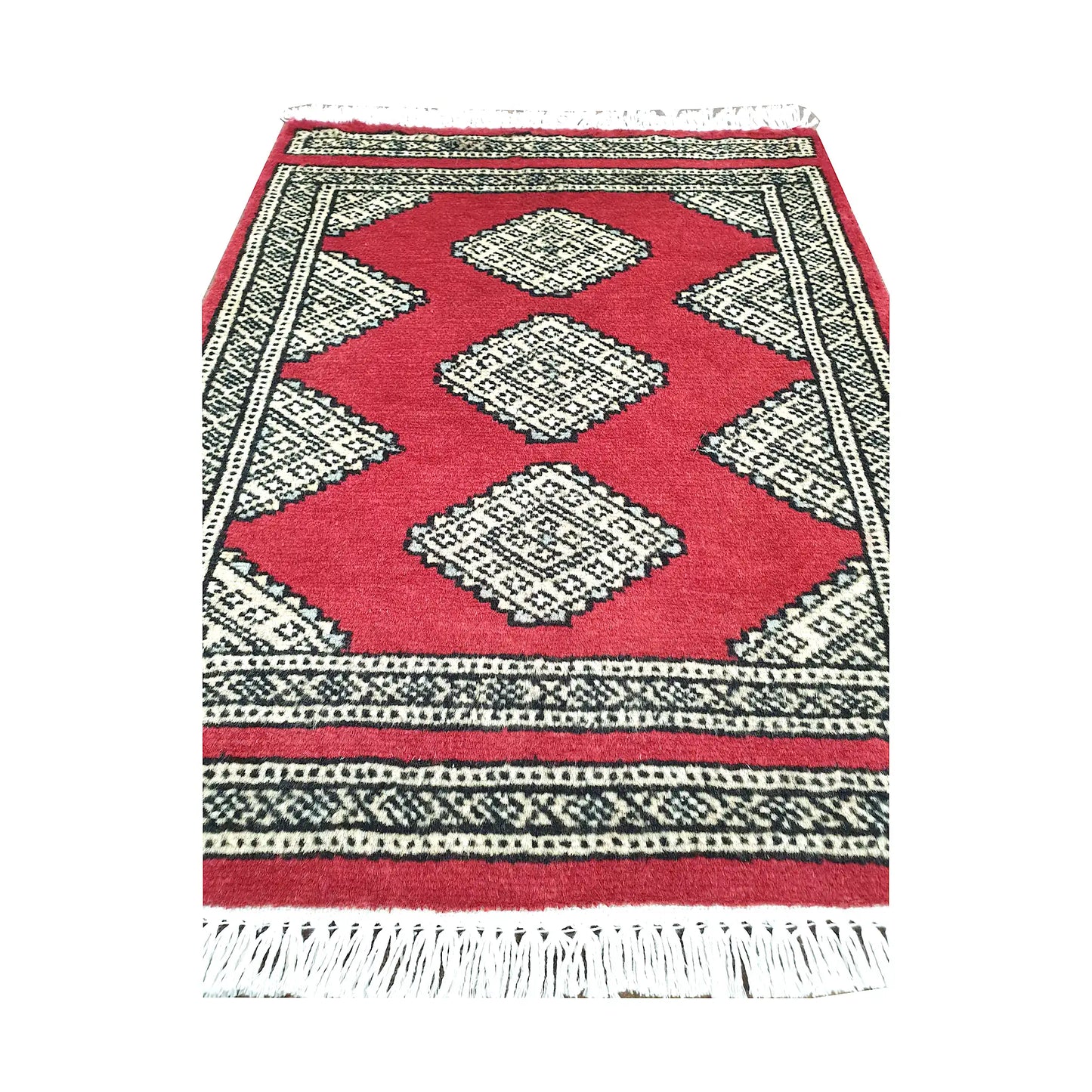 Red field and border detail of Afghan Jaldar wool rug showing ivory diamond medallions and geometric border