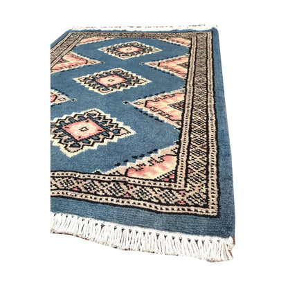 Angled fringe and border detail of Afghan Jaldar wool rug showing blue-grey pile, ivory motifs and dark edging