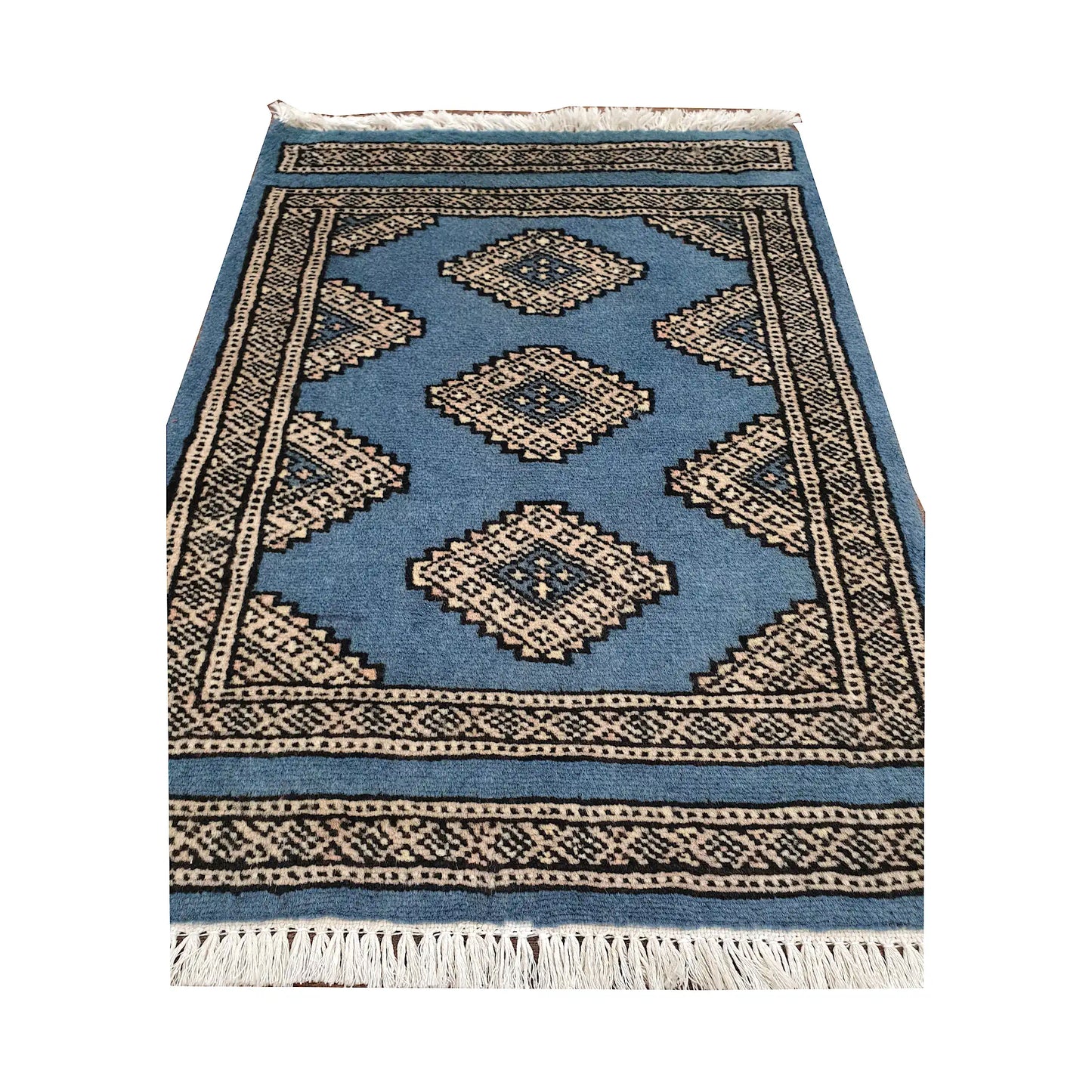 Blue field and border detail of Afghan Jaldar wool rug showing ivory diamond medallions and traditional border pattern