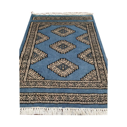 Blue field and border detail of Afghan Jaldar wool rug showing ivory diamond medallions and traditional border pattern