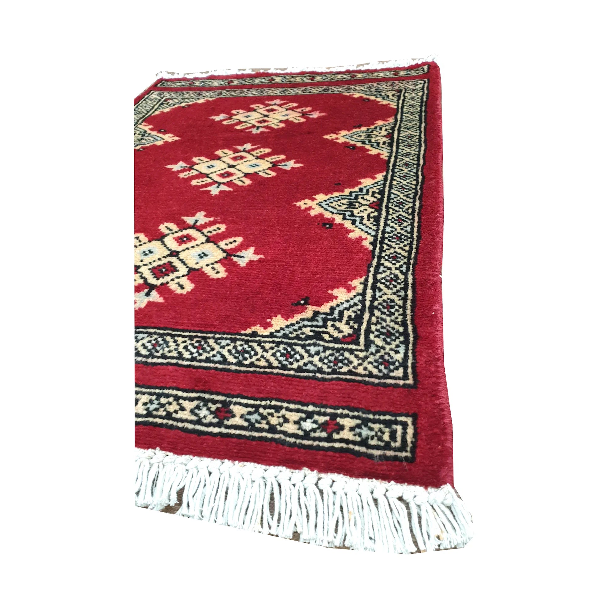 Angled fringe and border detail of Afghan Jaldar wool rug showing red pile, ivory diamond motifs and dark geometric edging
