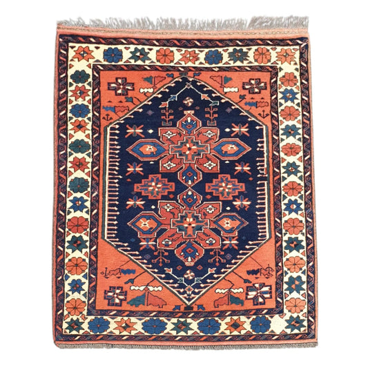Full view of Afghan Karghai hand-knotted wool rug with warm orange field, navy medallion and cream floral border, 138 x 108 cm