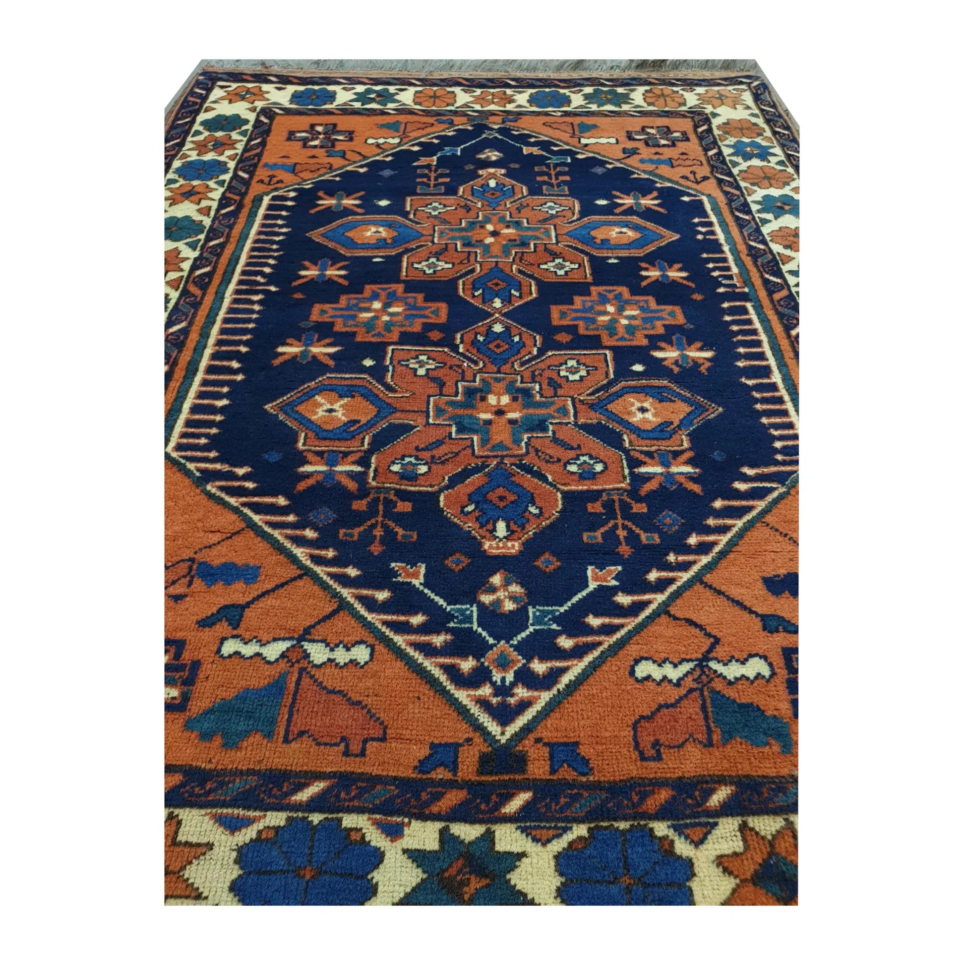 Close-up of Afghan Karghai wool rug showing the detailed navy floral medallion, orange field and border motifs