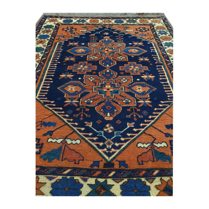 Close-up of Afghan Karghai wool rug showing the detailed navy floral medallion, orange field and border motifs