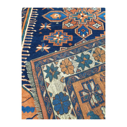 Folded corner detail of Afghan Karghai rug showing the navy patterned field, border and reverse side