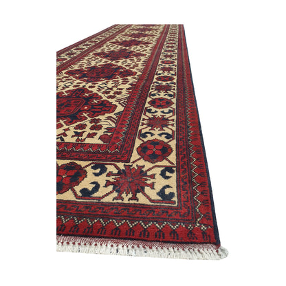 Angled border and fringe detail of Afghan Karghai runner rug showing ivory field, red border and wool texture