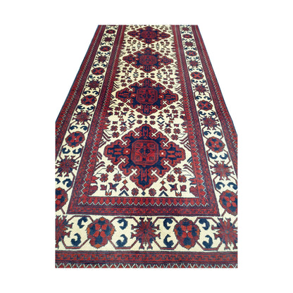 End field detail of Afghan Karghai runner rug with ivory ground, burgundy medallions and floral border