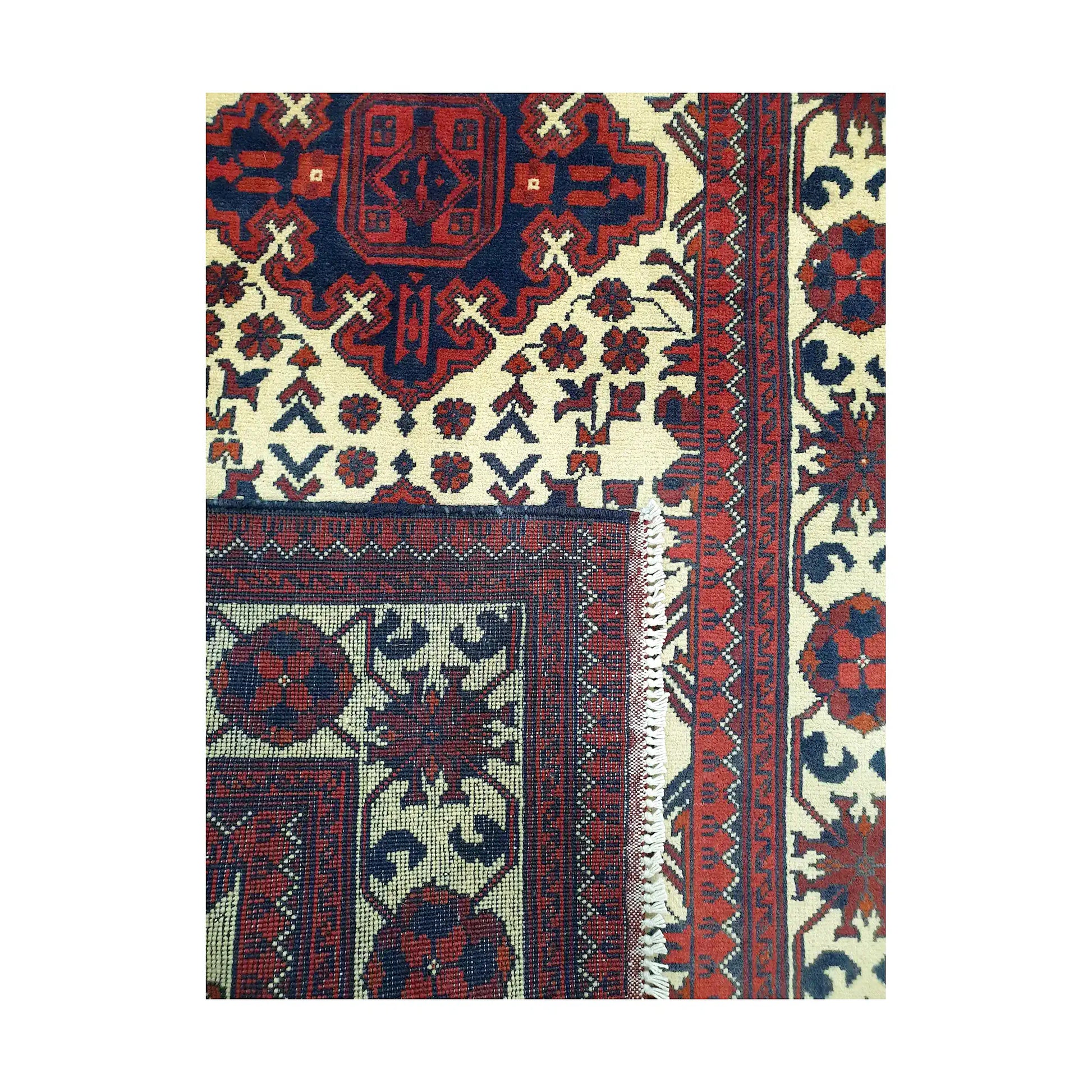 Folded corner detail of Afghan Karghai runner rug showing the back of the rug, fringe and front border pattern