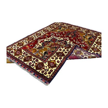 Folded view of Afghan Karghai rug showing its central medallion, ivory diamond border and a section of the reverse