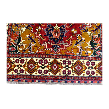 End-border detail of Afghan Karghai rug showing ochre and red pattern above repeating burgundy diamonds on an ivory ground