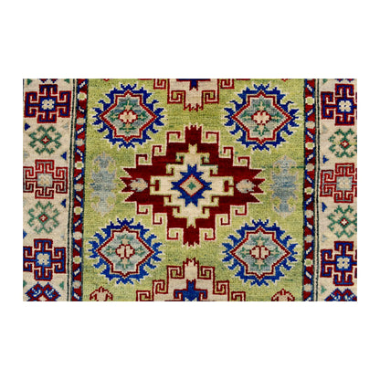 Central medallion detail of Afghan Kazak wool rug showing red, blue, cream and muted green geometric motifs