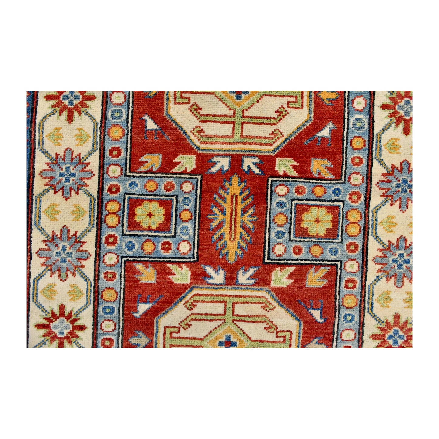 Field and medallion detail of Afghan Kazak hand-knotted wool rug showing red, blue and muted green geometric motifs