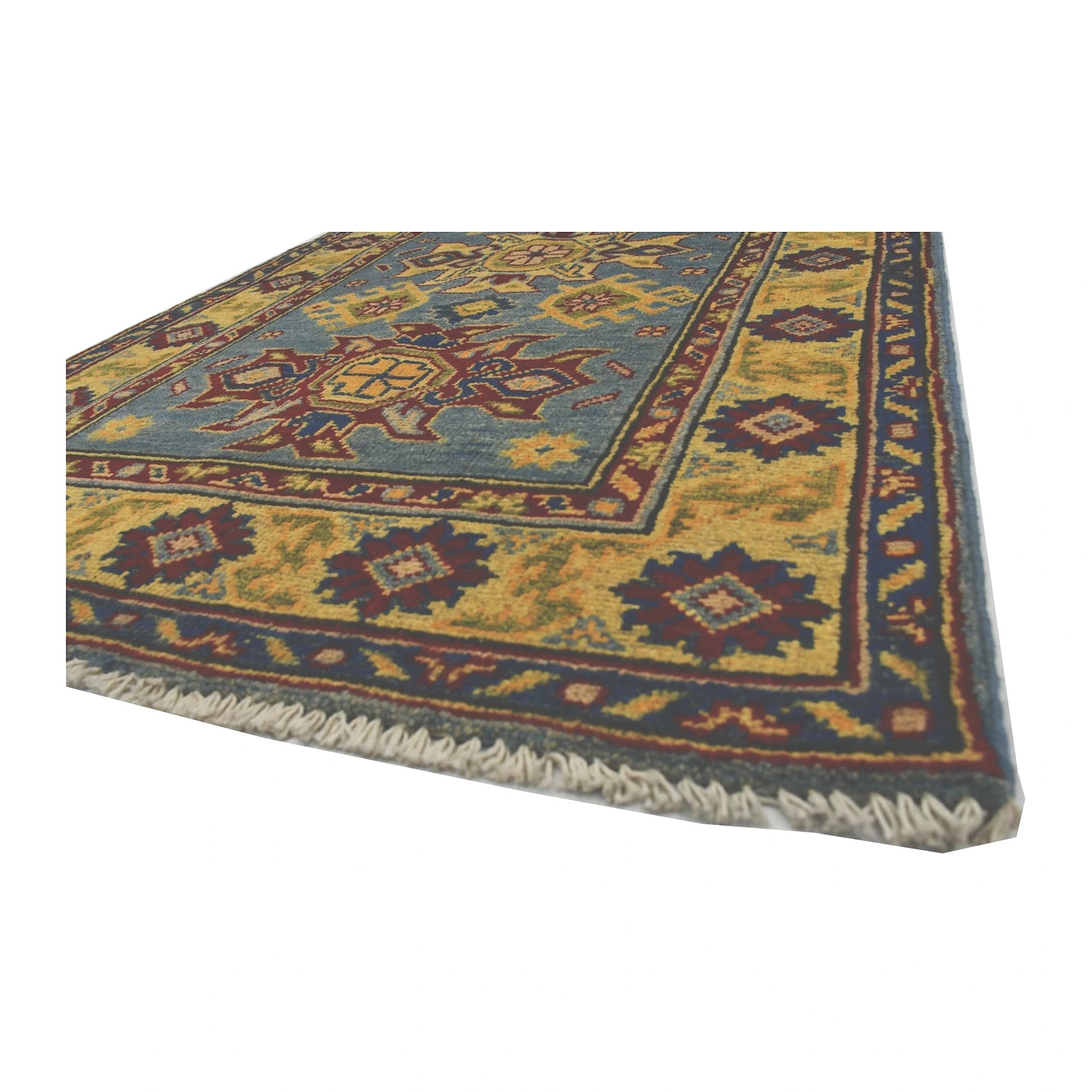 Angled corner and fringe view of Afghan Kazak wool rug showing light blue field, yellow border detail and light fringe