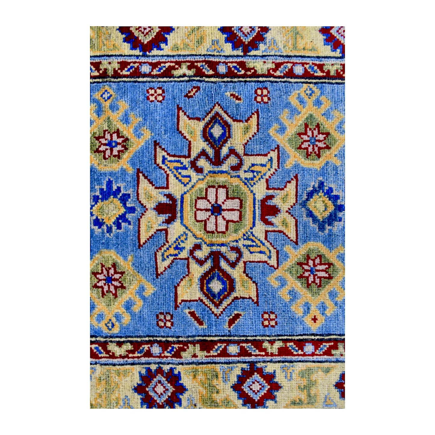 Central medallion detail of Afghan Kazak wool rug showing light blue field with red, cream, yellow and navy geometric motifs