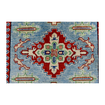Central medallion detail of Afghan Kazak wool rug showing red, ivory, navy and muted green geometric motifs