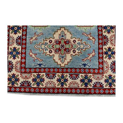 Field and border detail of Afghan Kazak hand-knotted wool rug showing light blue ground, stepped medallion and patterned border