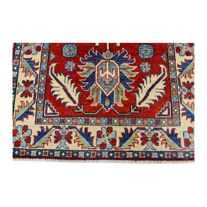 End medallion and border detail of Afghan Kazak hand-knotted wool rug showing red field, cream border and light blue accents