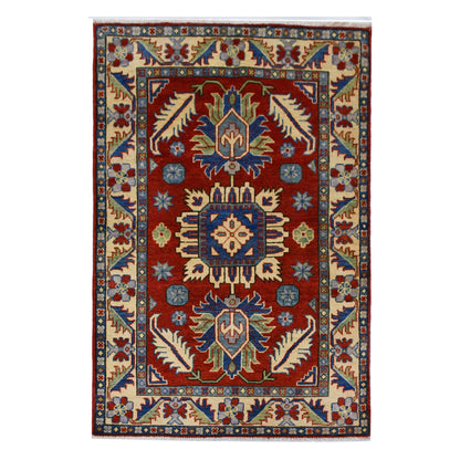 Full view of Afghan Kazak hand-knotted wool rug with red field, geometric medallions and cream border, 156 x 100 cm